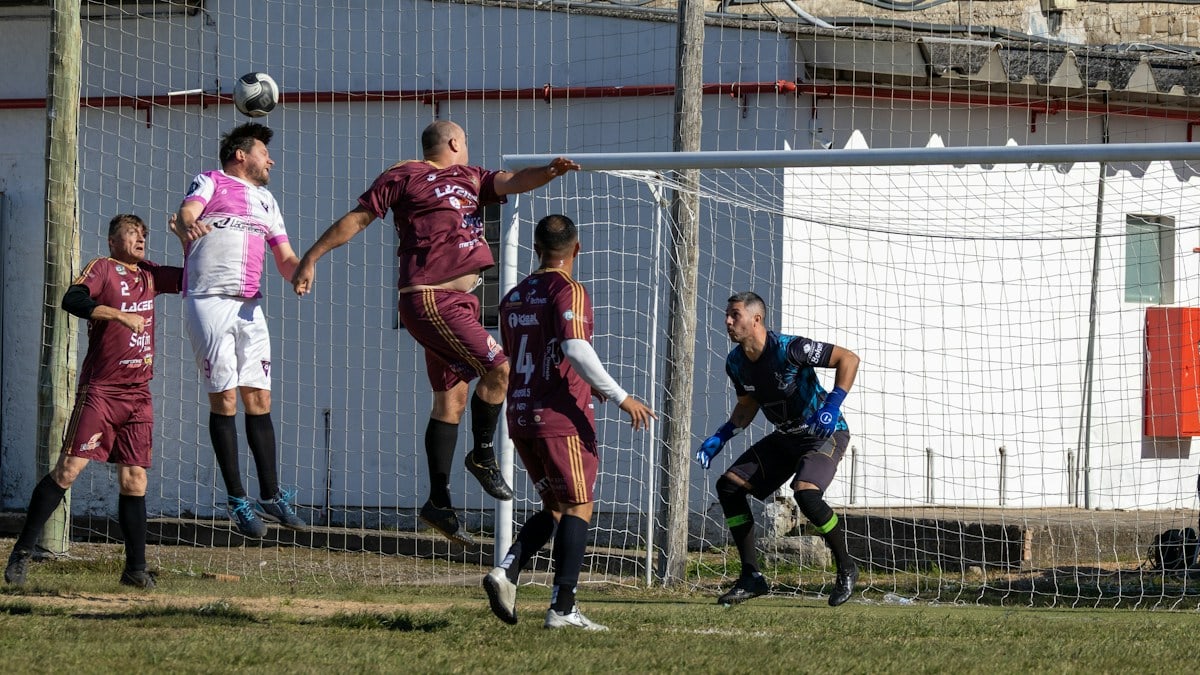 Soccer players compete for the ball in front of goal