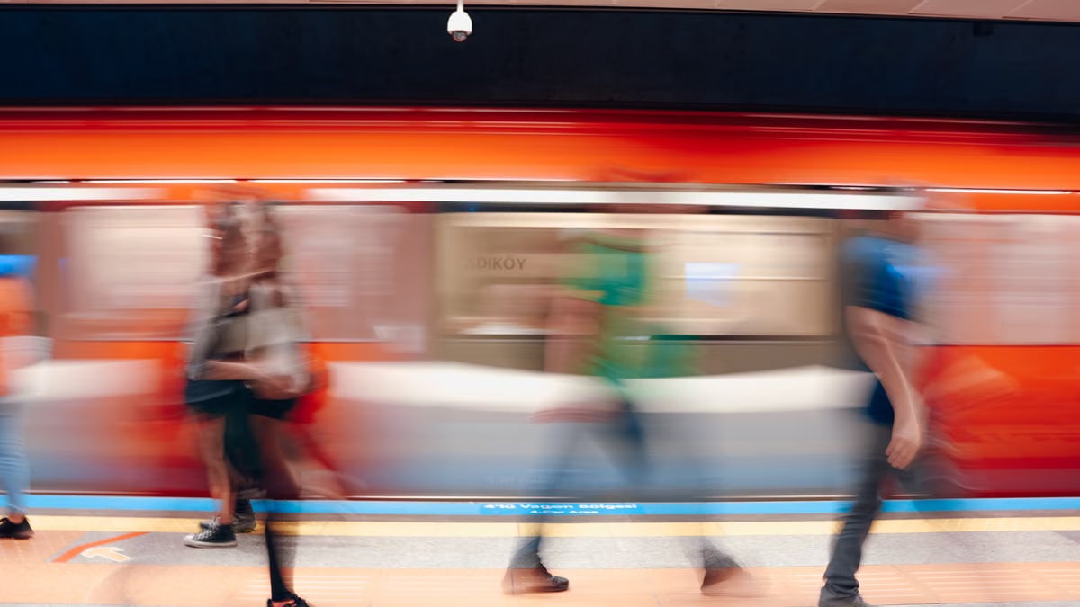 Dynamic scene of commuters in a subway station with motion blur capturing the rush.